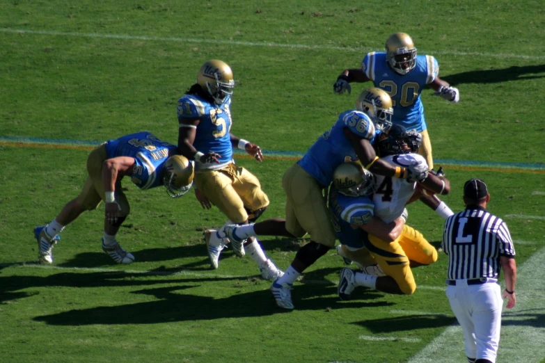 three running football players fight over the ball