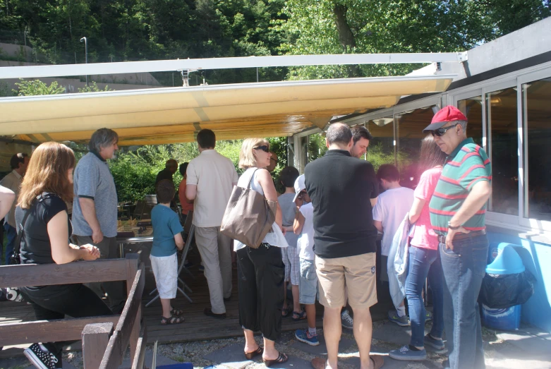 people gathered outside in front of an open roof tent