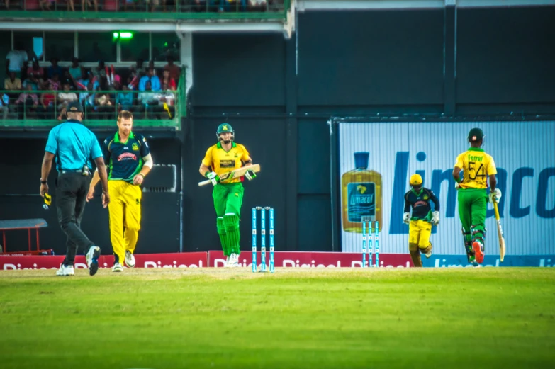 some men in uniforms playing a game of cricket