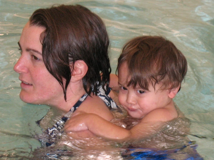 a woman holding a boy in the water