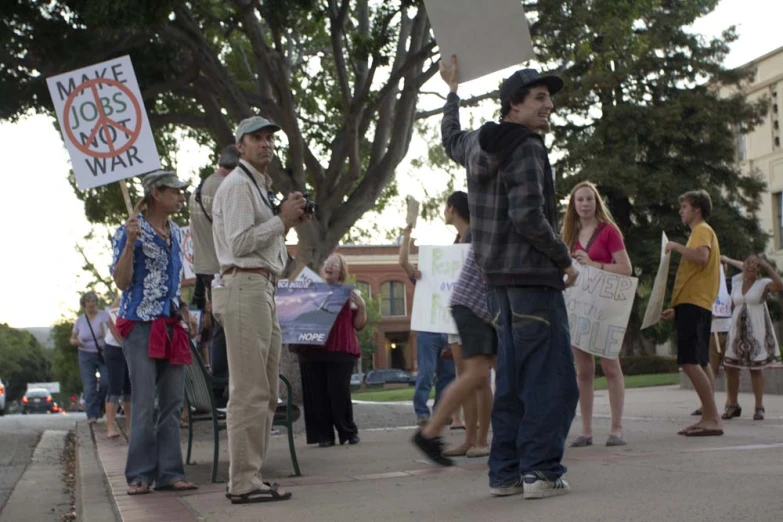 a crowd of people standing next to each other on a street