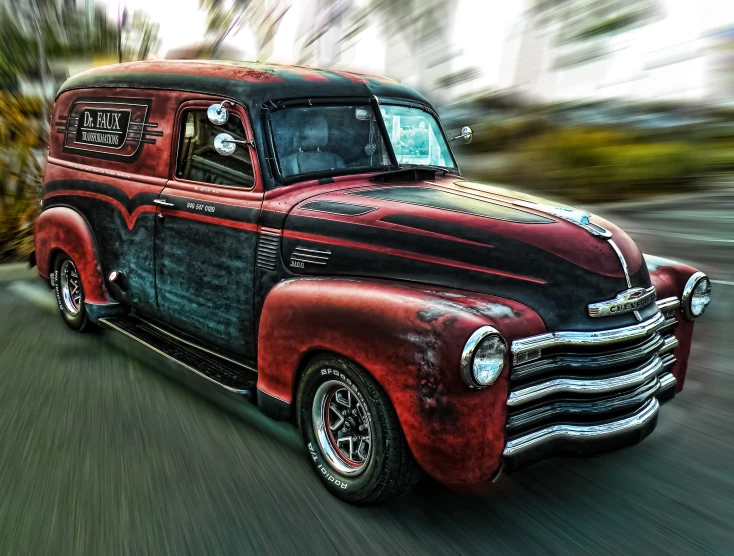 an antique red and black truck on the road