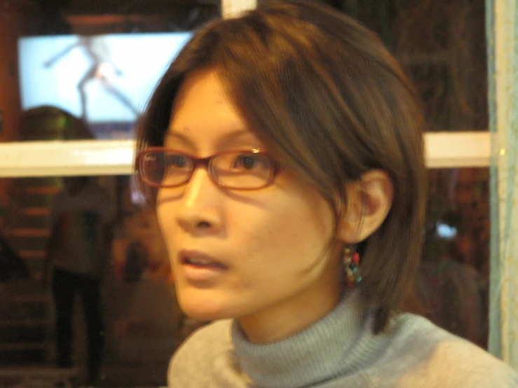 a woman with glasses looking away from the camera