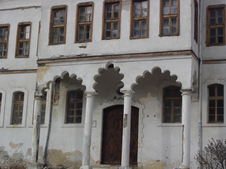 the front view of a very old white building with columns and an entryway