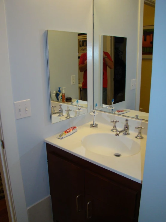 a very small mirror and sink in a room