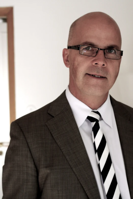 a bald man in a suit and striped tie