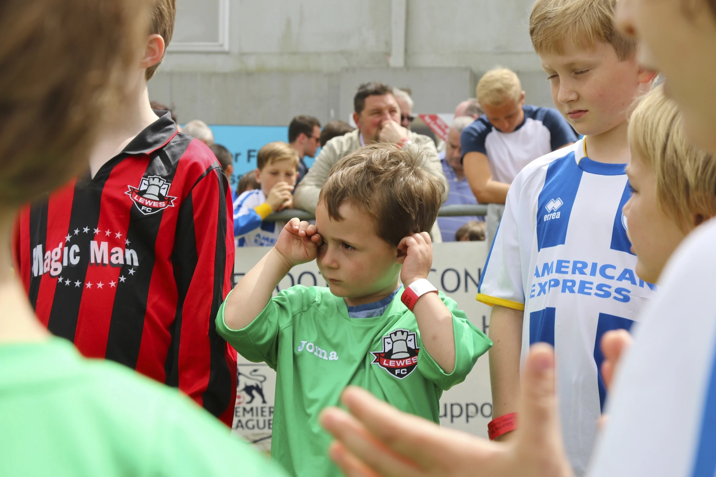 children watch soccer play on the sidelines of the arena