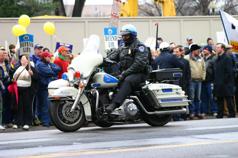 there is a police officer that is riding on his motorcycle