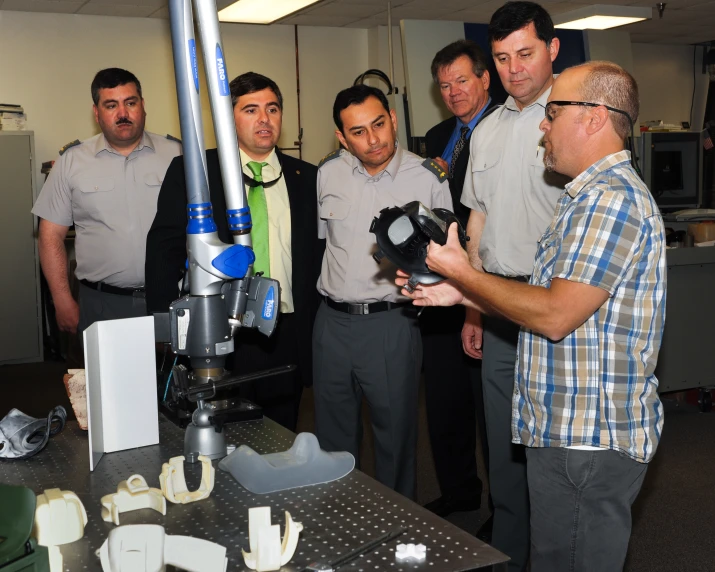 four men standing around one of the men in front of the camera take pictures