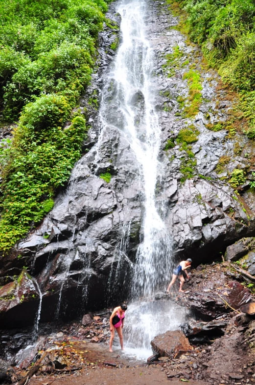 people standing in front of a waterfall as water is flowing