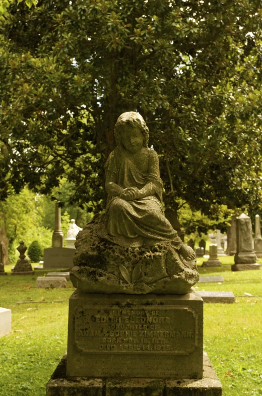 a statue sitting on top of a green field