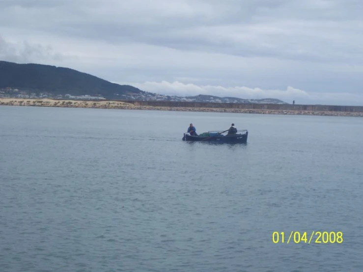 two people in a small boat on a body of water