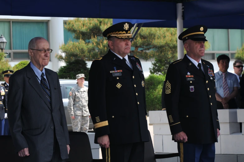 the two men in military uniforms are standing next to each other