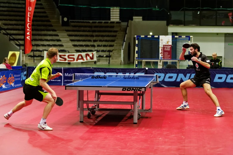 men standing next to each other playing table tennis