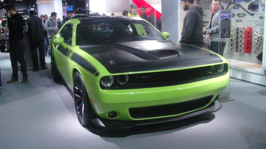 the green dodge muscle sits on display at a show