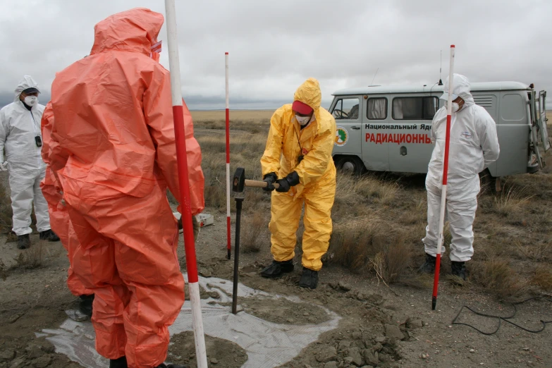 men in chemical suits standing around an outdoor field