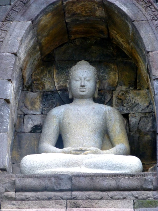 a statue of a buddha sitting inside a cave