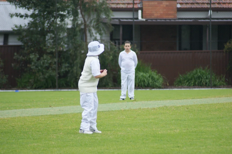 two children in white outfits playing with a flying disk