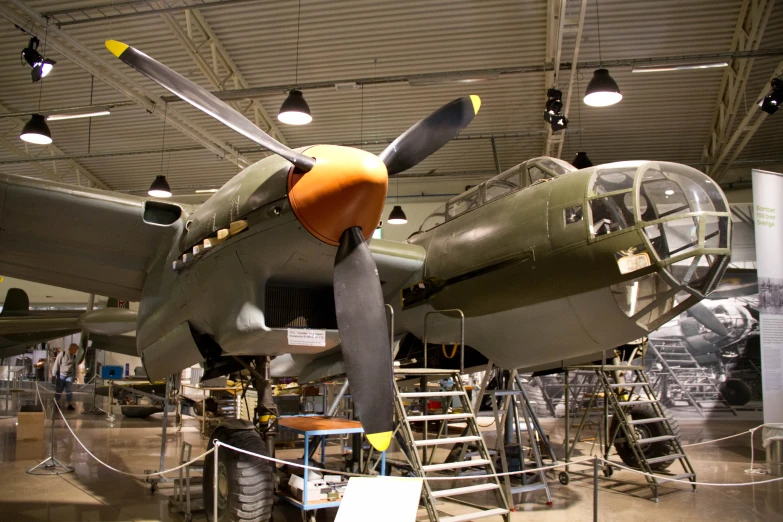 old plane in hangar with ladder and lights