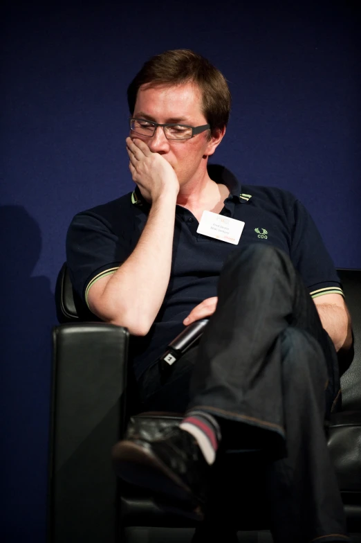 a man sitting on a chair while looking at soing