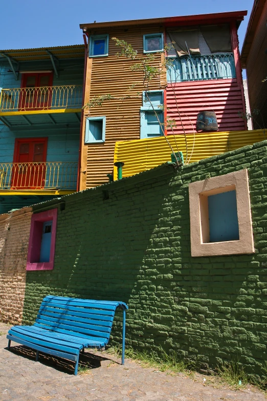 two different colored buildings and one bench that looks like it's from the outside