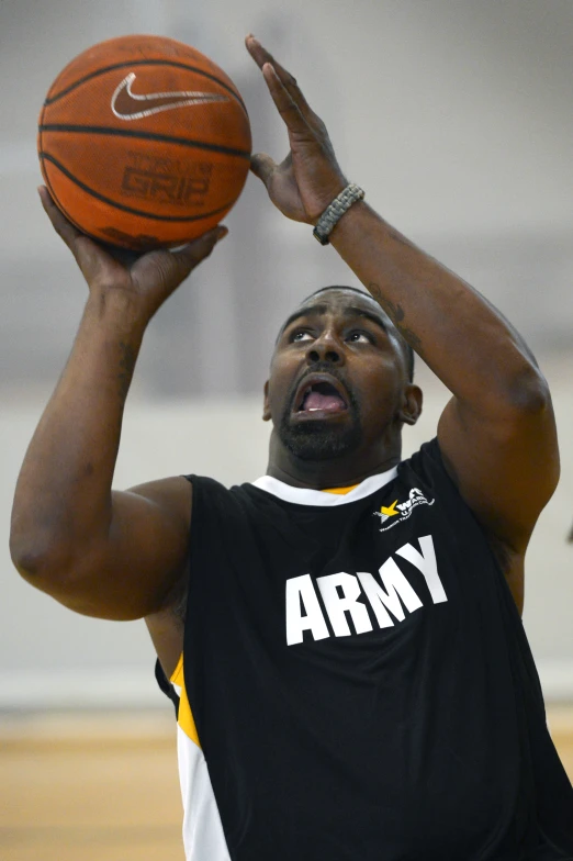 an army man is holding his basketball in the air