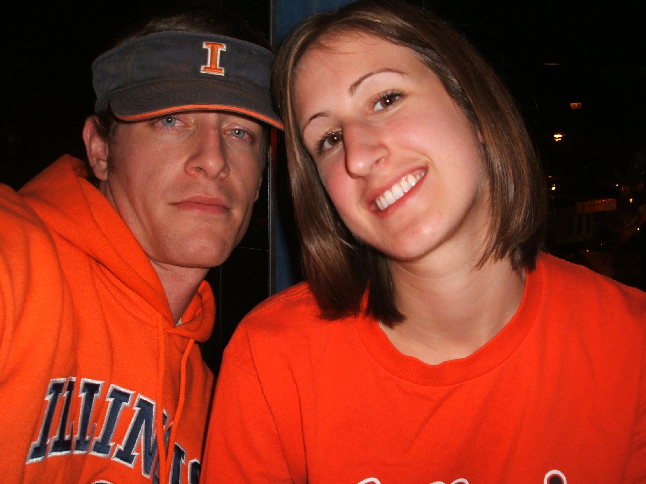 two people posing for the camera at night