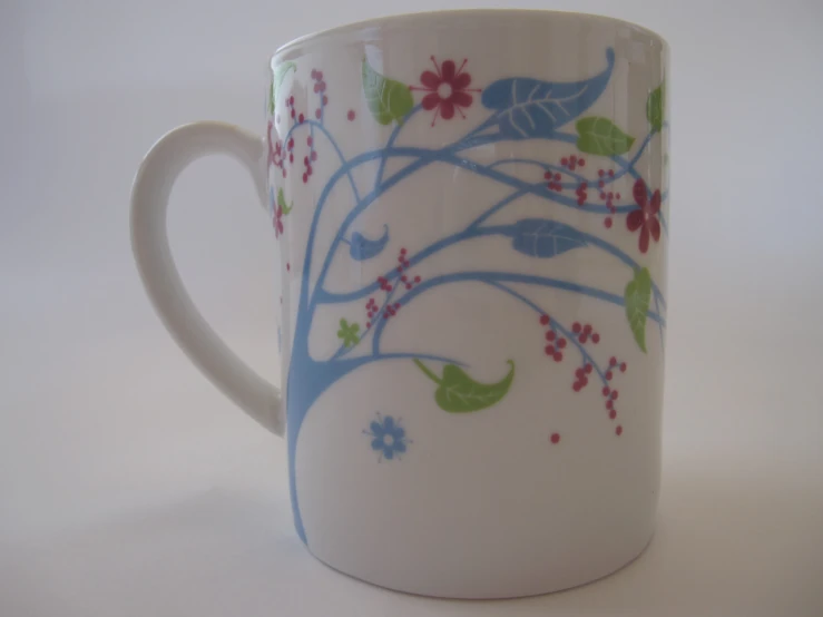 there is a small mug with a flower design