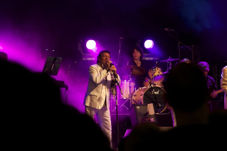 the musician performs with his band on stage