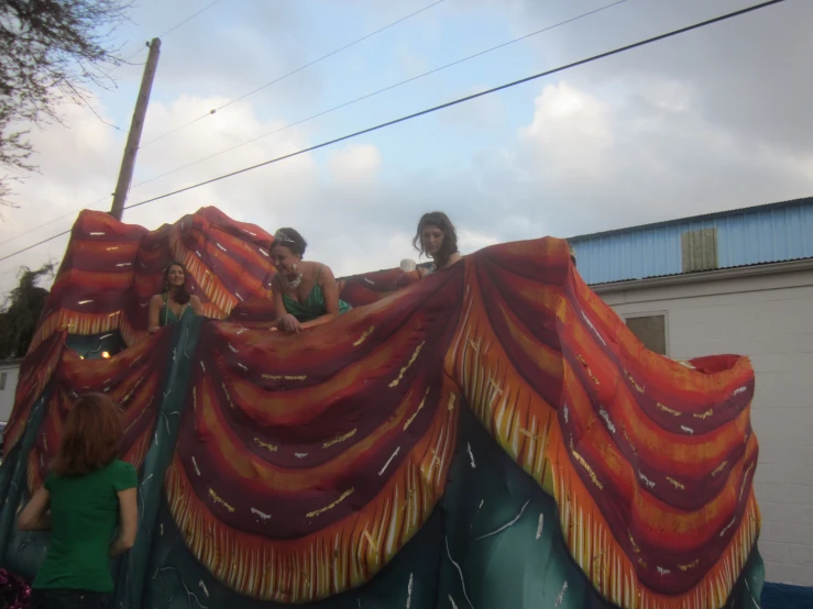 people are standing near a giant, tent like piece of art