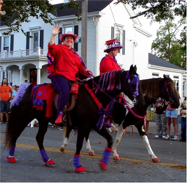 the two men are riding horses down the street