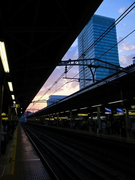 some people wait on the train platform for a ride