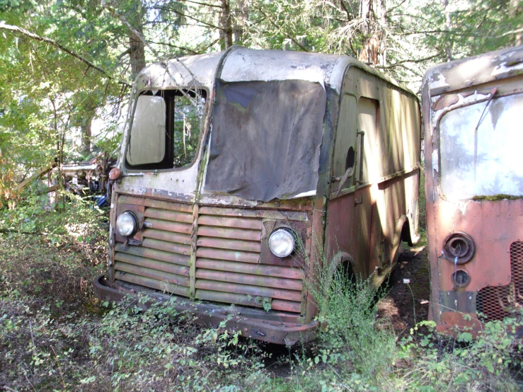 an old rusted, run down truck is sitting in the woods