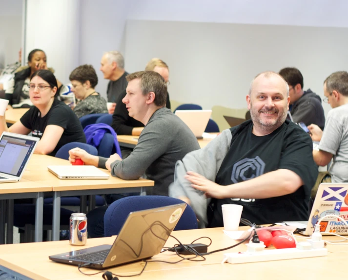 a group of people sitting in chairs with lap tops