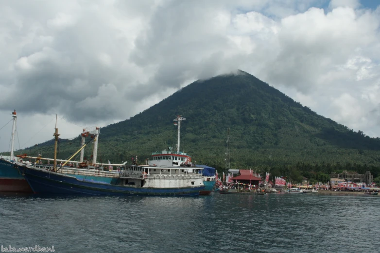 boats are sitting on the water next to a mountain