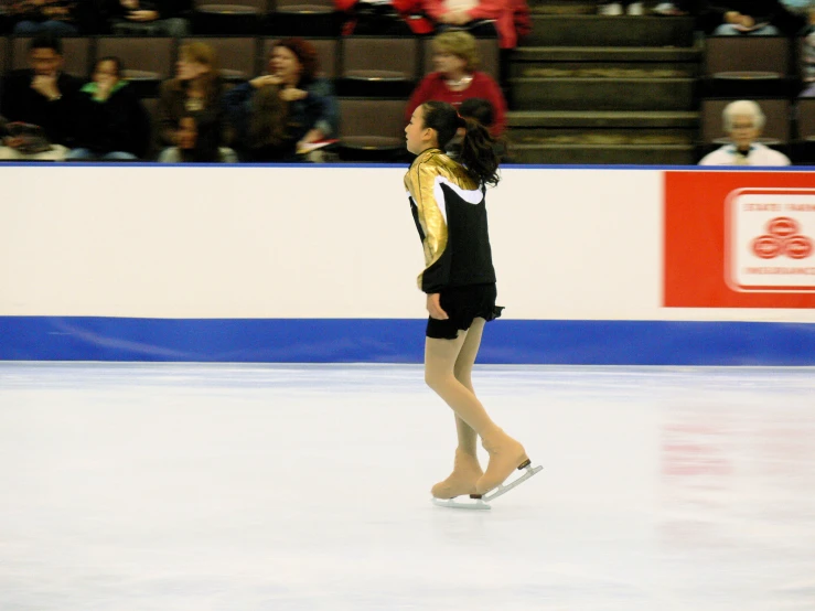 a young female skates on an ice rink