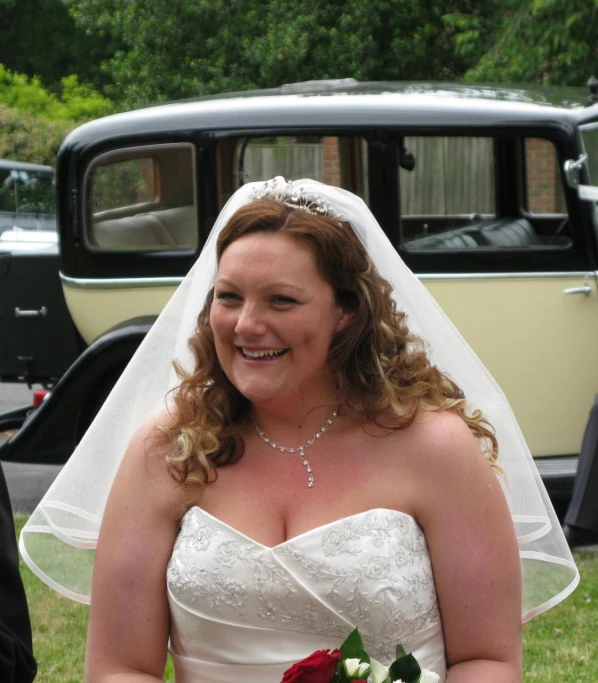 an attractive bride poses for a po in front of an old bus