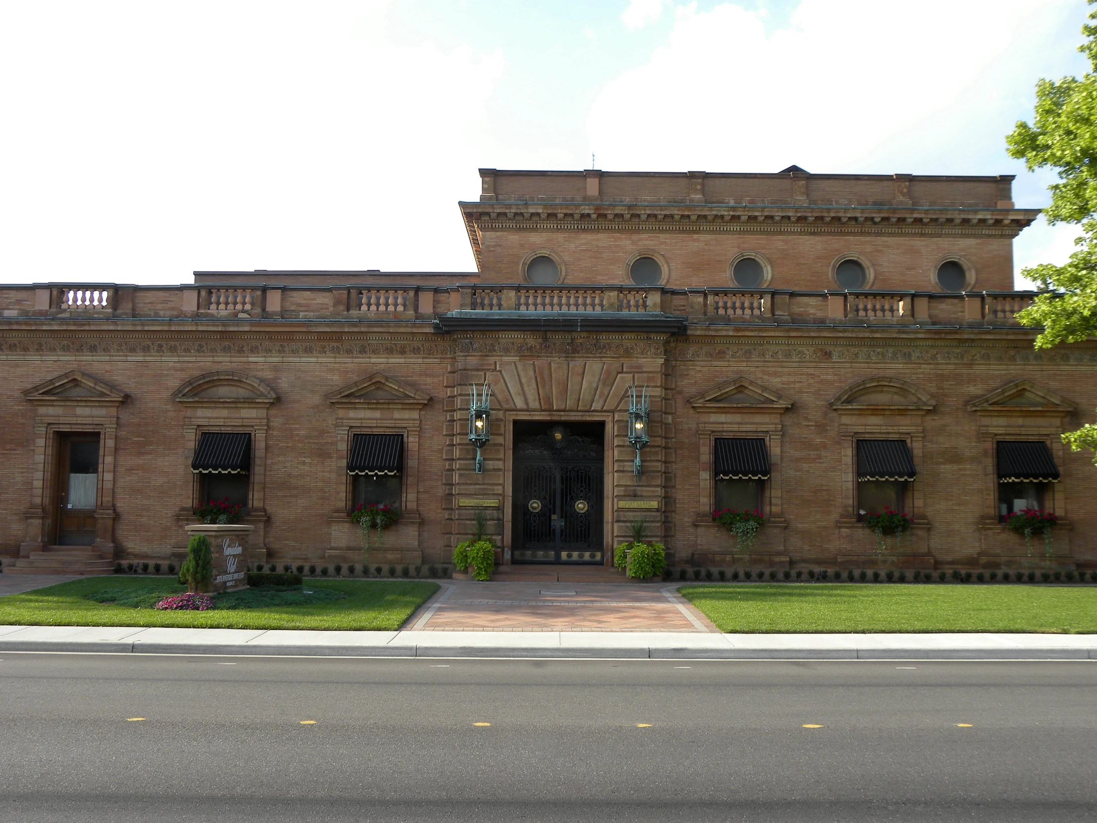 large brick building with two windows and large balcony