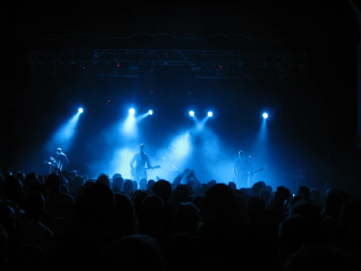 a band on stage at a concert in front of a crowd