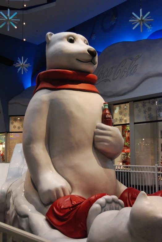 a large white bear statue sitting next to a baby polar bear