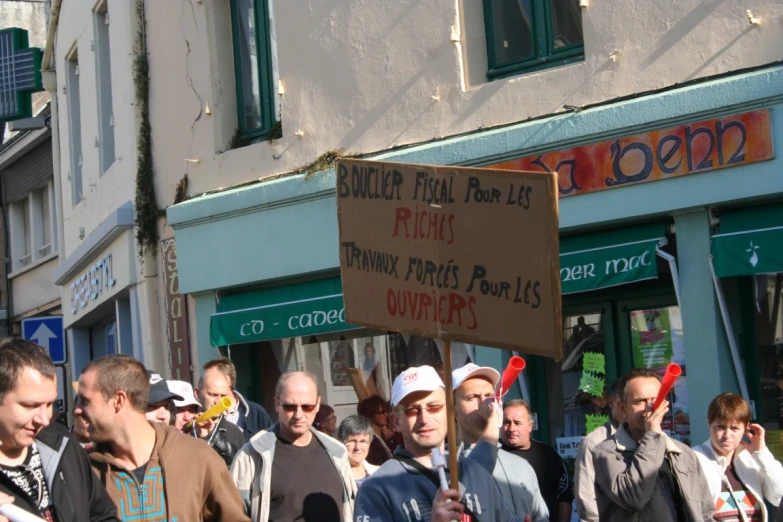 several men stand outside, one holds up a sign that reads never roll rolls