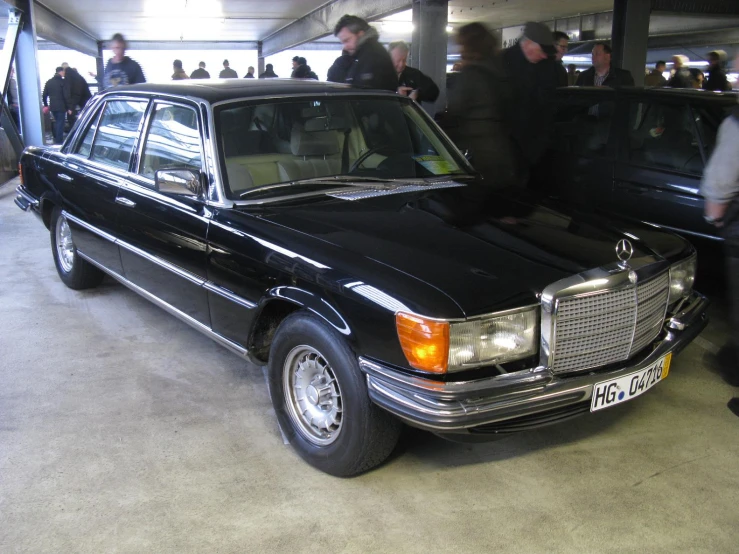 an old black mercedes is parked inside a building