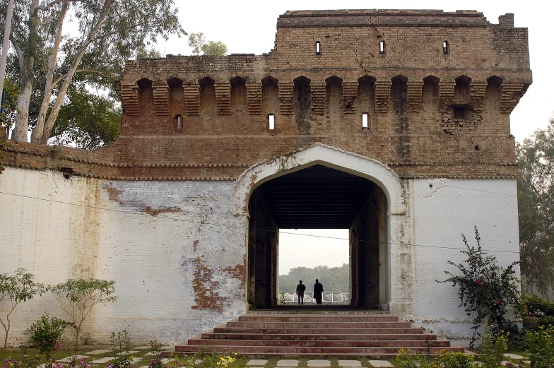 a po of people walking into an old gate