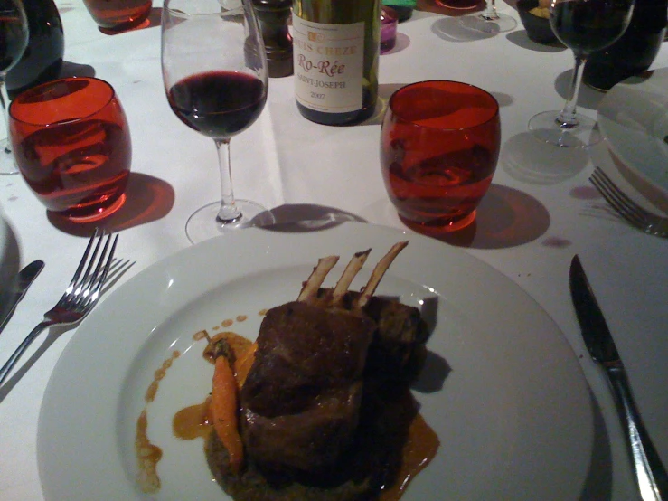 steak on a plate with gravy and wine glasses