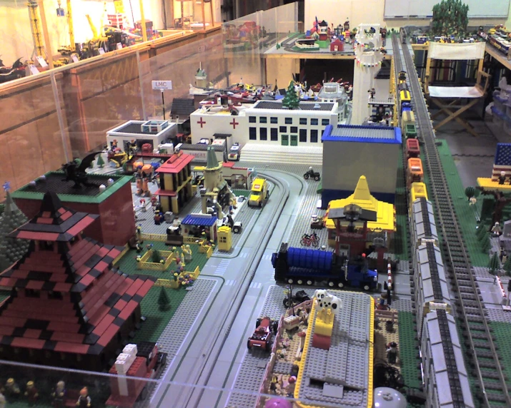 model city scene with train tracks, people and vehicles