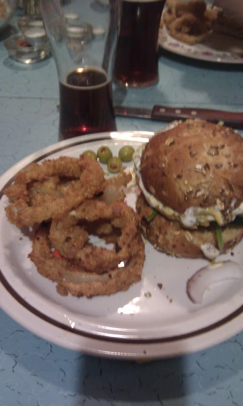 a hamburger and onion rings on a white plate