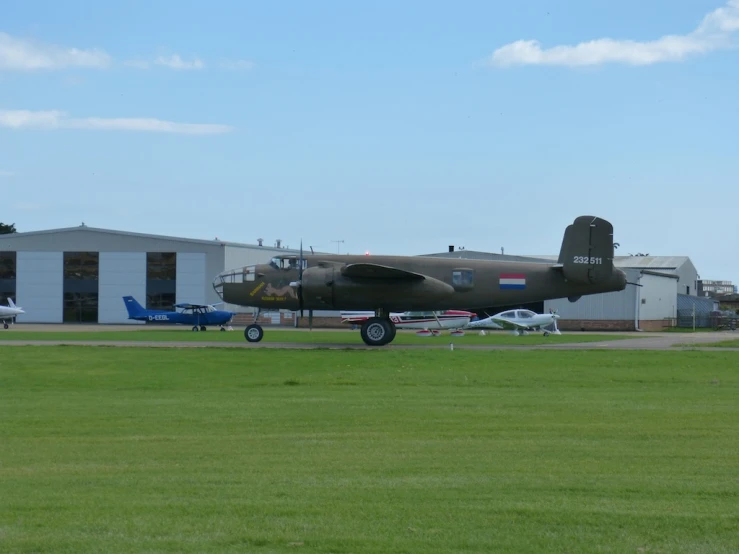 an airplane sits on the ground in front of an hangar