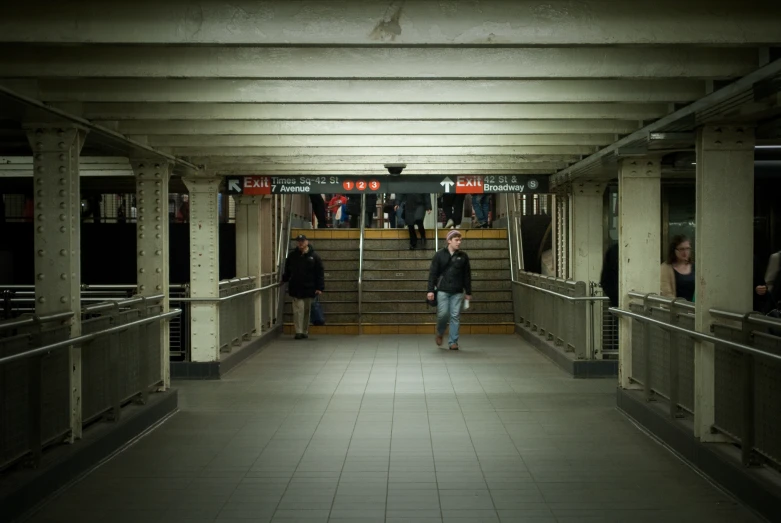 people walking up a walkway in an empty building