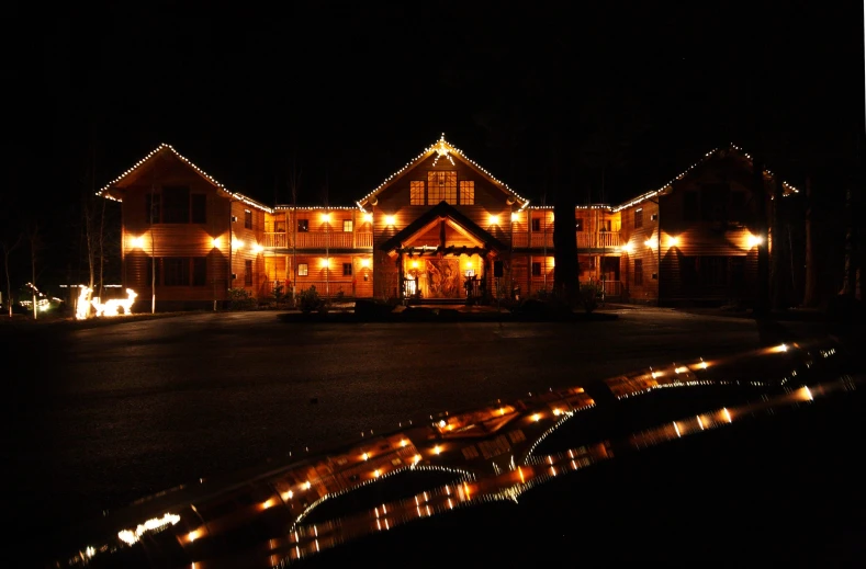 a lit up home at night with horse