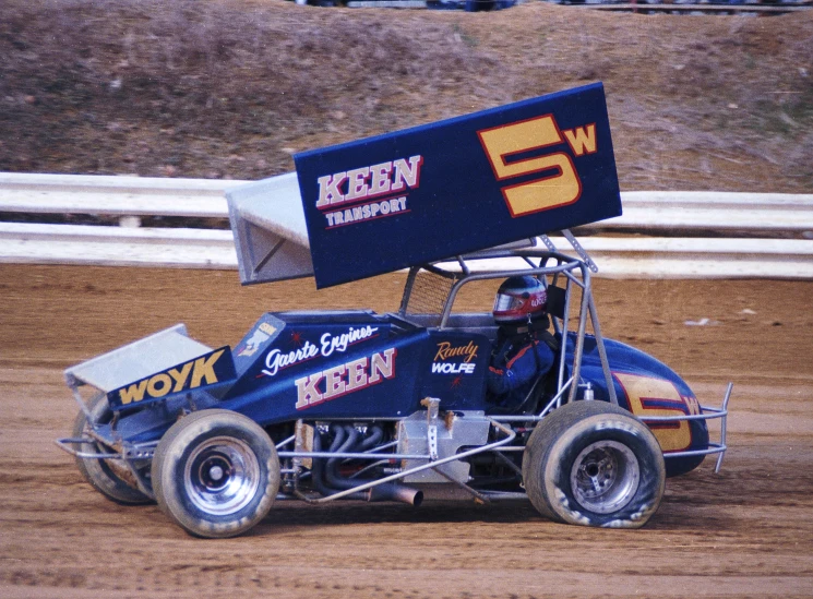 the small car is driving on the dirt track